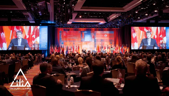 تصویر یک همایش بزرگ مدیریتی با حضور مدیران ارشد و نمایش پرچم‌ کشورها؛ نمادی از نقش کلیدی کلاب‌های مدیریتی در ارتقای سطح مدیریت کشور از طریق آموزش، تعامل و تبادل تجربیات حرفه‌ای.