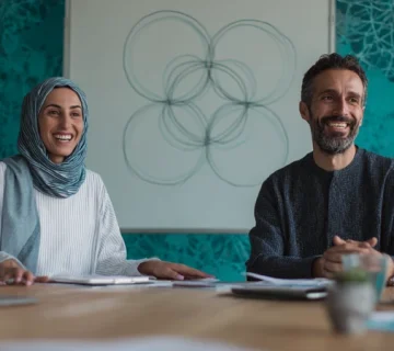 تصویر مذاکره حرفه‌ای بدون فشار با تمرکز بر مهارت مذاکره، قانع‌سازی و ارتباط مؤثر در یک دفتر مدرن ایرانی