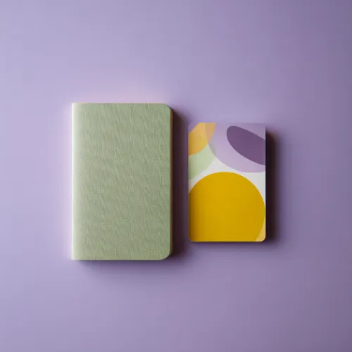 دو دفترچه مینیمال با رنگ‌های سبز، زرد و بنفش روی پس‌زمینه بنفش؛ تصویری نمادین از سادگی، انسجام و هویت بصری تحریریه وب‌سایت باشگاه مدیران و کارآفرینان مثلث.