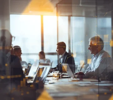 Iranian entrepreneurs and managers discussing low-risk business ideas in a modern Tehran co-working space, symbolizing entrepreneurship in Iran today