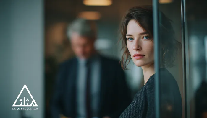 کارمند توانمند در محیط کاری مدرن که با نگاهی متفکر و فاصله‌گرفته از سازمان دیده می‌شود؛ نمادی از فرسودگی شغلی و تصمیم پنهان برای ترک محل کار در نتیجه اشتباهات مدیریتی در نگهداشت استعدادها